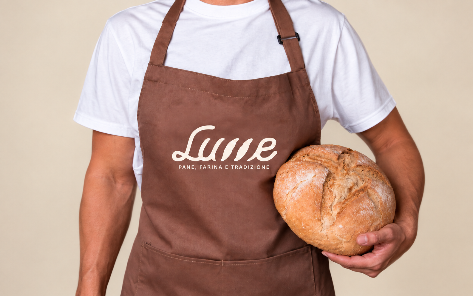 Grembiule marrone con marchio Lume e una pagnotta, su fondo beige
