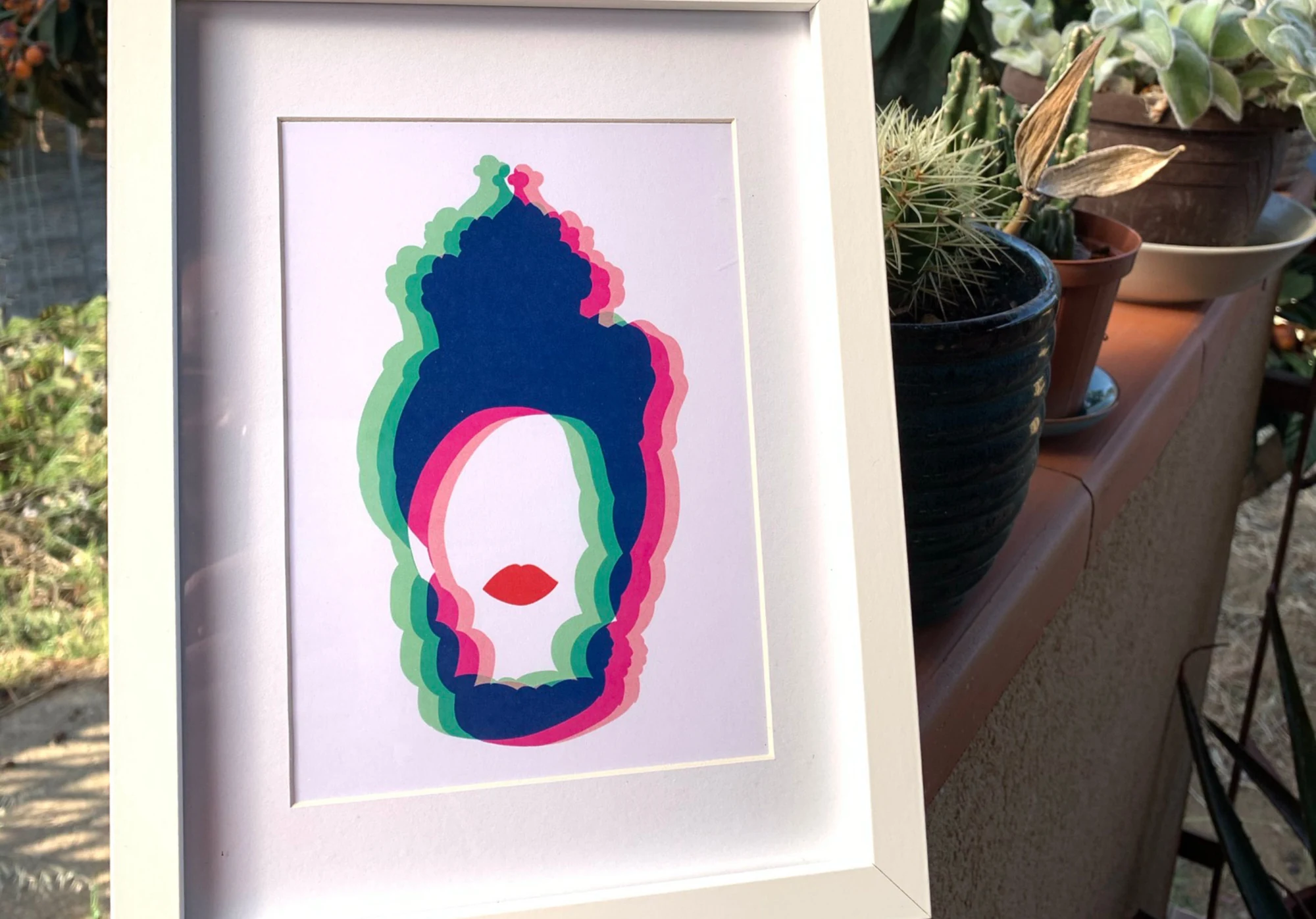 MOROMORA — volto con profili blu, rosa e verdi, incorniciato